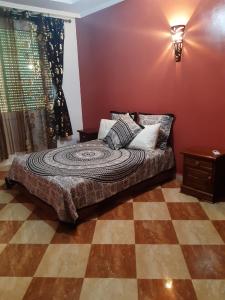 ein Schlafzimmer mit einem Bett in einem Zimmer mit roten Wänden in der Unterkunft Villa Fatima in Meknès