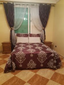 a bedroom with a large bed with a window at Villa Fatima in Meknès