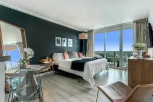 a bedroom with a bed, desk, chair and a window at iCoconutGrove - Luxurious Vacation Rentals in Coconut Grove in Miami