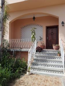 eine Treppe, die zu einem Haus mit schwarzen und weißen Fliesen führt in der Unterkunft Villa Fatima in Meknès