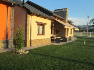 a house with a green lawn in front of it at APARTAMENTOS FONTE VILLAR in Navia