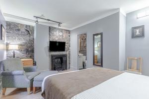 a bedroom with a bed and a fireplace at Hotel Jardin du Gouverneur in Quebec City