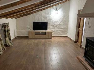 a living room with a flat screen tv on a cabinet at Casa Rural San Francisco I in Siles