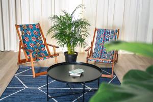a living room with two chairs and a table at CURIOCITY Green Point in Cape Town