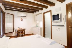 a bedroom with a bed and a kitchen with a table at Studio in San Marco square in Venice
