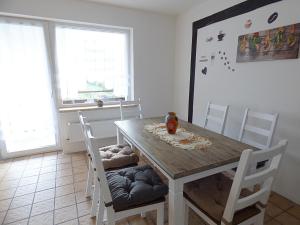una sala da pranzo con tavolo e sedie in legno di FeWo direkt am Wald und Wanderweg mit Balkon Ruhe pur 1 OG a Bad Sachsa