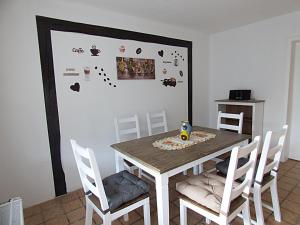 a dining room with a table and chairs and a wall at FeWo direkt am Wald und Wanderweg mit Balkon Ruhe pur 1 OG in Bad Sachsa +5 photos