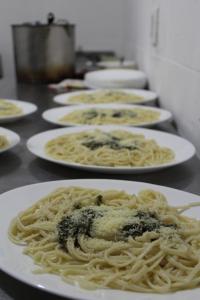 a row of plates of pasta on a table at Aji Hostel in Santiago