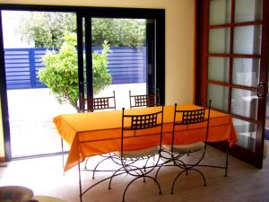 uma mesa amarela com quatro cadeiras num quarto em Magnifica casa con jacuzzi y cerca playa ref 160 em Montjoys