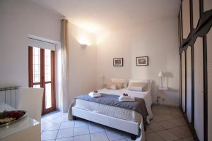 a white bedroom with a bed and a window at Magenta Collection Purificazione in Rome