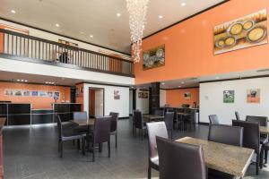 comedor con mesas, sillas y paredes de color naranja en Motel 6-Ennis, TX, en Ennis