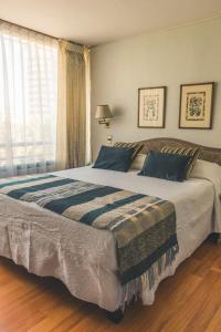 1 cama grande en un dormitorio con ventana en Alessandria Apart - El Bosque Norte, en Santiago