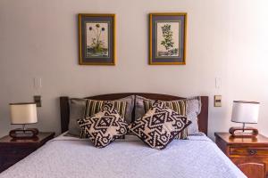 a bedroom with a bed with pillows and two lamps at Alessandria Apart - El Bosque Norte in Santiago