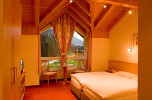 a bedroom with a bed and a large window at Adrian in Sankt Anton am Arlberg