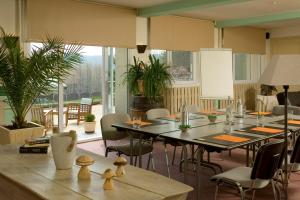 a dining room with tables and chairs and windows at Bel Horizon in Le Chambon-sur-Lignon