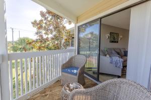 a porch with wicker chairs and a living room at La Casa Del Mar 608 Star5Vacations in Dunedin