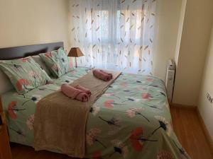 1 dormitorio con 1 cama con 2 almohadas rosas en APARTAMENTO MOTA-2 HUCA-LOS PRADOS; PARKING Y WIFI GRATIS, en Oviedo