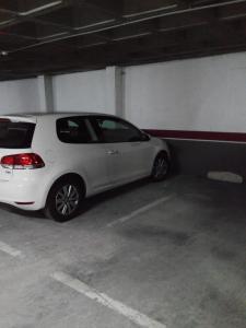un coche blanco aparcado en un garaje en APARTAMENTO MOTA-2 HUCA-LOS PRADOS; PARKING Y WIFI GRATIS, en Oviedo