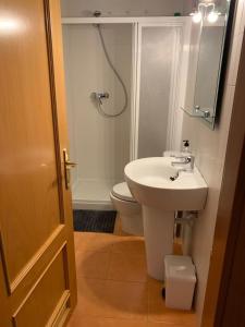 y baño con lavabo blanco y aseo. en APARTAMENTO MOTA-2 HUCA-LOS PRADOS; PARKING Y WIFI GRATIS, en Oviedo