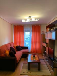 sala de estar con sofá y mesa en APARTAMENTO MOTA-2 HUCA-LOS PRADOS; PARKING Y WIFI GRATIS, en Oviedo