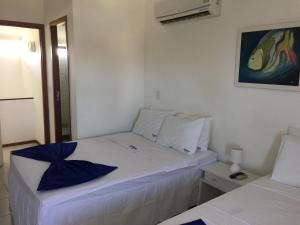a white bedroom with two beds in a room at Nannai Beira Mar Porto de Galinhas 307 in Porto De Galinhas