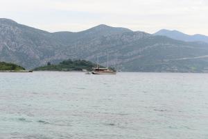 ein Boot im Wasser mit Bergen im Hintergrund in der Unterkunft Apartments MAK in Račišće