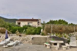 una casa con mesa y sillas y un edificio en Apartments MAK, en Račišće