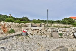 a stone wall with a bucket in front of it at Apartments MAK in Račišće
