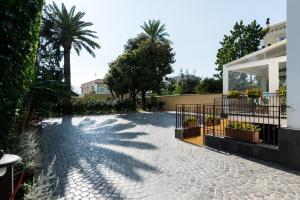 a walkway in front of a house with palm trees at Dream House Pompei in Pompei