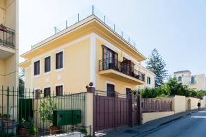 a yellow and white house with a fence at Dream House Pompei in Pompei