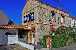 a brick building with a tv on the side of it at Logis Hôtel La Chaize in Noirmoutier-en-l'lle