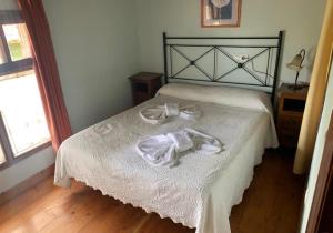 1 dormitorio con 1 cama y 2 toallas blancas en APARTAMENTOS MARIAJE en Barro de Llanes