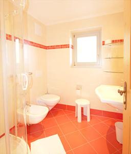 a bathroom with two toilets and a sink at Pension Maria in Antermoia