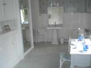 a white bathroom with a sink and a mirror at Demeure les Montys in Haute-Goulaine