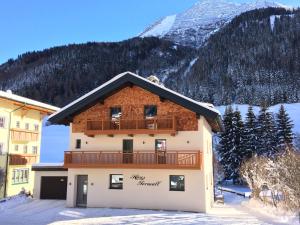 a building with a balcony and a mountain in the background at Ferienhaus Ferwall in Sankt Anton am Arlberg