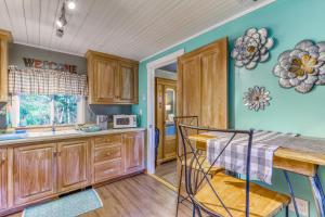 cocina con armarios de madera y mesa en Little House in the Big Woods en Freeland