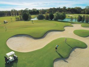 a golfer is playing on a golf course at Jacaranda Holiday Units in Swan Hill
