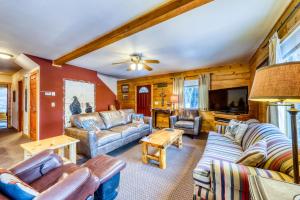 a living room with leather furniture and a flat screen tv at Big Timber in McCall