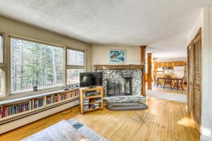 a living room with a fireplace and a tv at Edson Hill in Stowe
