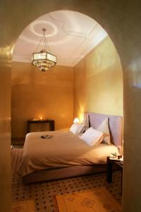 1 dormitorio con cama y lámpara de araña en Riad L'Emir, en Marrakech