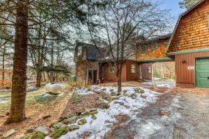 a house with a green garage in the snow at Edson Hill in Stowe