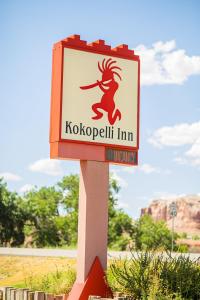 a sign for a koko spell inn on a pole at Kokopelli Inn in Bluff