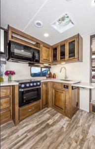 a kitchen with wooden cabinets and a sink at Delight's Hot Springs Resort in Tecopa