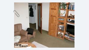 sala de estar con sofá, silla y TV en Ferienwohnung harZauber, en Braunlage