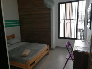 ein Schlafzimmer mit einem Bett, einem Fenster und einem Stuhl in der Unterkunft 338 Home Hosting in Cali