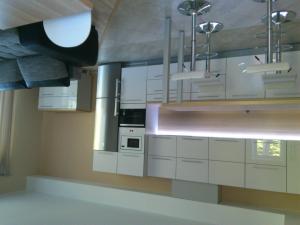 una cocina con armarios blancos y electrodomésticos de acero inoxidable en Pansionaat Valentina, en Narva-Jõesuu