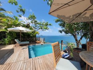 a swimming pool with a table and an umbrella at Hotel Boutique Siete Lunas in Sayulita