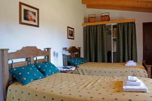a bedroom with two beds with blue pillows at Quinta Pero Vicente in Odeceixe