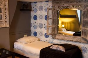 a bedroom with two beds and a mirror at Hotel Matuchi in Maastricht