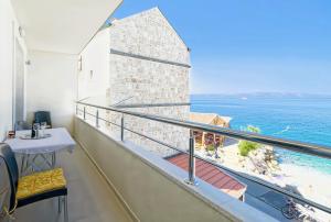 a balcony with a table and a view of the ocean at Apartman More&Maslina in Drasnice